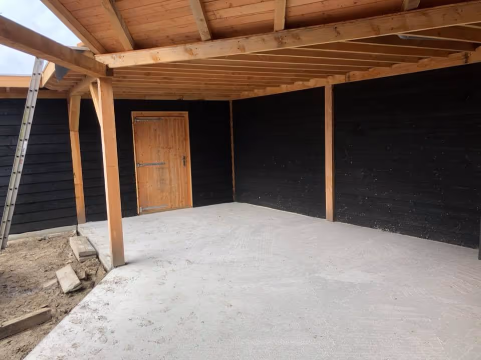 A living room with a white armchair, a coffee table with decor, and potted plants.
